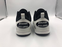 a pair of white and black sneakers with a black logo on them