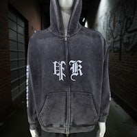 a black zip up hoodie with white letters on it